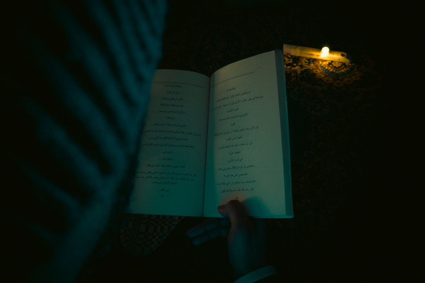 A person holds an open book while reading quietly.